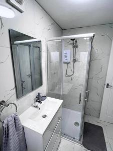 y baño blanco con lavabo y ducha. en Harmony home Lindley Huddersfield, en Lindley