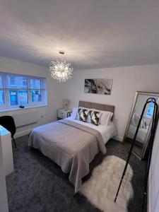 a bedroom with a large bed and a chandelier at Harmony home Lindley Huddersfield in Lindley