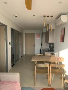 a kitchen and dining room with a wooden table and chairs at Premium The Sóng 5sao P Homestay in Vung Tau