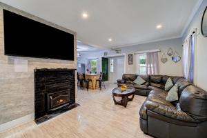 a living room with a couch and a fireplace with a flat screen tv at Catskill's Cozy Farmhouse Getaway in Gilboa