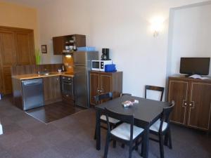 a kitchen with a table and chairs and a kitchen with a microwave at Appartement Standing Château des Magnans in Jausiers