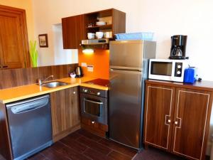 a kitchen with a stainless steel refrigerator and a microwave at Appartement Standing Château des Magnans in Jausiers