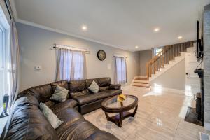 a living room with a leather couch and a table at Rustic Catskills Farmhouse with Lake Views & Wildlife in Gilboa