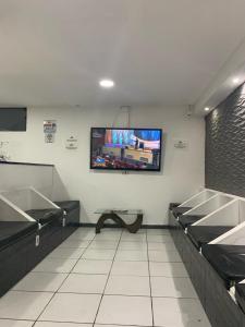 uma sala de espera com uma televisão de ecrã plano na parede em Estação Hostel - Em frente ao Metrô em São Paulo