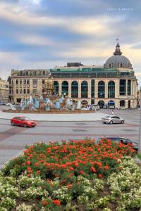 a large building with cars driving in front of it at Lux Palace Hotel in Kutaisi