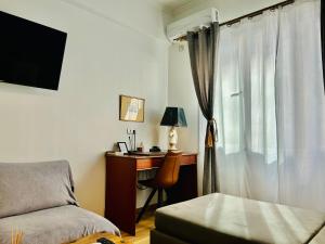 a bedroom with a desk and a bed and a window at Royal Blue Grand Suite No 3 in Piraeus