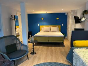 a bedroom with a bed and a blue wall at MUZE Hotel Utrecht in Utrecht