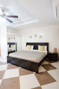 a bedroom with a bed and a checkered floor at Aparta Hotel Roma in Santo Domingo
