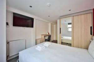 a bedroom with a large white bed and a mirror at 03.Studio#Charenton#Fitness#Cinema in Charenton-le-Pont