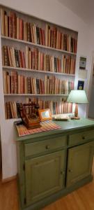 a desk with a lamp in front of a wall of books at Suite dei Doria in Dolceacqua