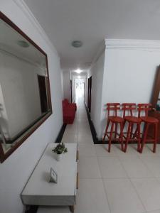 sala de estar con TV de pantalla plana y sillas rojas en HOTEL VIP COMFORT, en Santa Marta