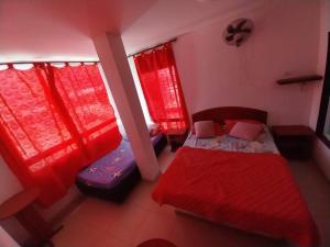 1 dormitorio pequeño con cortinas rojas y 1 cama en HOTEL VIP COMFORT, en Santa Marta
