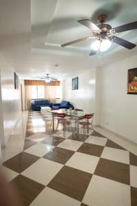 uma sala de estar com uma ventoinha de tecto e uma mesa e cadeiras em Aparta Hotel Roma em Santo Domingo