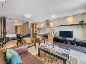 Una sala de estar con un sofá y un televisor. en Soak up canal views, Walk to V&A Waterfront and CTICC, en Ciudad del Cabo