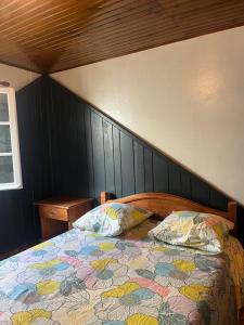 Un dormitorio con una cama con un edredón colorido. en La villa Creole - location saisonnière Cilaos, en Cilaos 16 fotos más