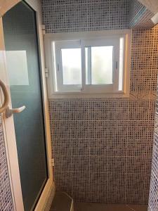 La salle de bains est pourvue d'une douche et de 2 fenêtres. dans l'établissement La villa Creole - location saisonnière Cilaos, à Cilaos