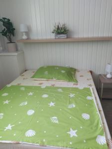 Bett mit grüner Decke mit weißen Sternen in der Unterkunft Kolpingház Pécs in Pécs