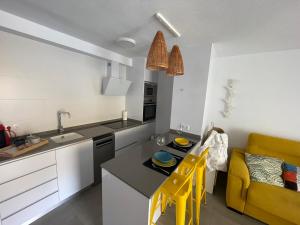 een keuken met een gele stoel en een keukentafel bij Estudio Primera línea de Playa in Tavernes de la Valldigna