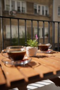 a wooden table with two cups and a potted plant on it at Merkuri apartments in Istanbul