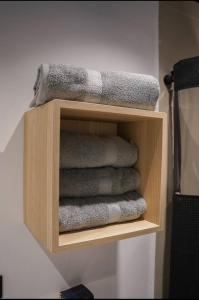 - une pile de serviettes sur une étagère en bois dans la salle de bains dans l'établissement North Breeze Guest House 2, à Toa Baja