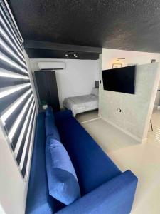 - un canapé bleu dans une chambre avec une télévision dans l'établissement North Breeze Guest House 2, à Toa Baja