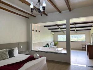 a bedroom with a tub and a bed in a room at Pousada Santa Fe de Penedo in Penedo