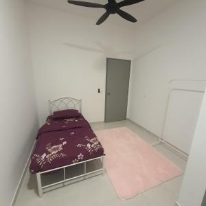 um quarto com uma cama e uma ventoinha de tecto em D Laman Haris Homestay em Bandar Puncak Alam