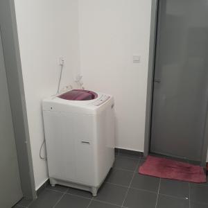 uma máquina de lavar e secar roupa branca na casa de banho com chuveiro em D Laman Haris Homestay em Bandar Puncak Alam