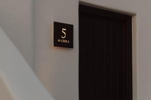 um sinal numa parede ao lado de uma porta preta em Laguna Suites in Mazera Mykonos em Míconos
