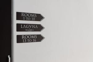 um grupo de sinais apontando em diferentes direções em Laguna Suites in Mazera Mykonos em Míconos