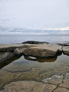um corpo de água com rochas e o oceano em Meri-Porin lomakoti 