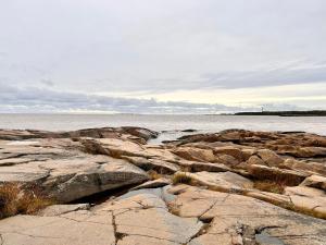 um grupo de rochas na margem da água em Meri-Porin lomakoti 
