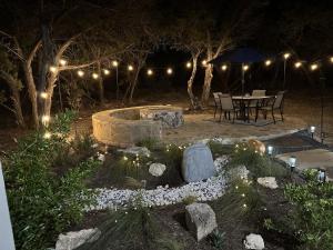 a patio with a table and an umbrella at night at Tranquil Oasis near Canyon Lake home in Spring Branch