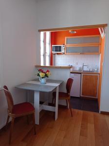 a small kitchen with a table and two chairs at Foudebassan in La Teste-de-Buch