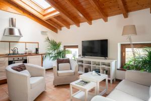uma sala de estar com mobiliário branco e uma televisão de ecrã plano em Apartments Bellagio em Bellagio