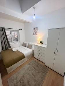 a white bedroom with a bed and a window at Cosy Stunning Flat in London