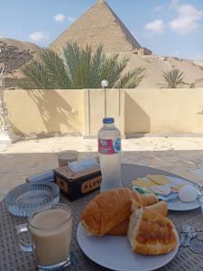 開羅的住宿－Mamado PYRAMIDS VIEW，一张桌子,上面放着一盘面包和一瓶水