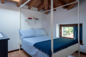 1 dormitorio con cama con dosel y ventana en Apartments Bellagio, en Bellagio