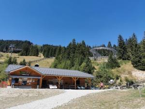 a log building with a roller coaster in the background at Appartement vue panoramique au pied des pistes in La Ferrière