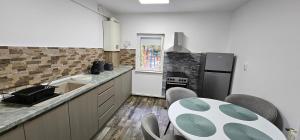 a kitchen with a table and a refrigerator at Apartament Like Home in Carei