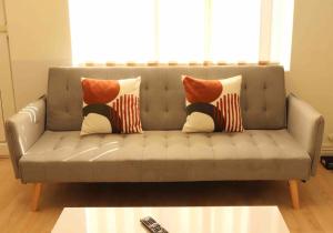 un sofá con almohadas en la sala de estar en Stunning Guest House FREE WiFi &Parking, en Hunslet
