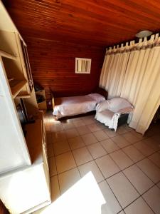 Habitación pequeña con 2 camas en una casa en Cabañas La Delfina en Puerto Iguazú