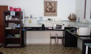 uma cozinha com um balcão com 2 bancos e um micro-ondas em Parque Suites Com Ar Condicionado Piscina e Estacionamento no Guarujá