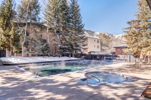 een zwembad in een tuin met sneeuw op de grond bij Chateau Roaring Fork Unit 22, Spacious Condo with Beautiful River Views, 4 Blocks to Town in Aspen