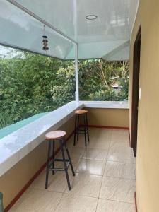 a balcony with two stools and a bar in a building at La Reina del Mar in Drake +13 photos