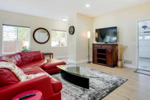 a living room with a red couch and a tv at Anchorage Retreat Charming Home with Private Deck! in Anchorage