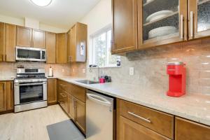 a kitchen with wooden cabinets and a counter top at Anchorage Retreat Charming Home with Private Deck! in Anchorage