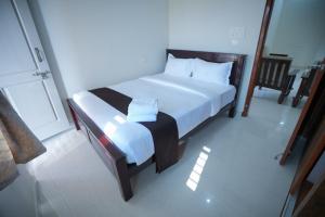 een slaapkamer met een groot bed met witte lakens bij Velvet Vista Premier Service Apartments in Mysore in Mysore