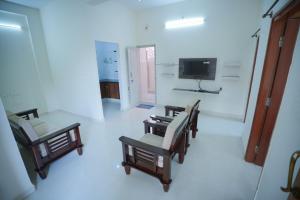 uma sala de estar com cadeiras e uma televisão e um quarto em Velvet Vista Premier Service Apartments in Mysore em Maiçor