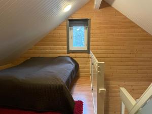 a bedroom with a bed in a attic with a window at Aapeli 1 in Ähtäri